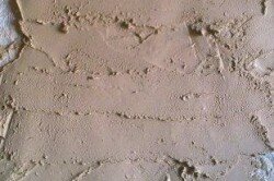 Свежий песчано-глиняный раствор, нанесенный на стену